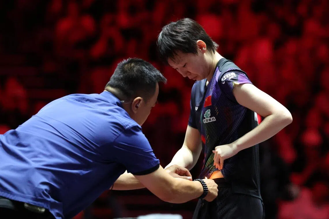 王曼昱（右）的球裤疑似在赛中出现脱线，在工作人员帮助下才解决问题。（郑一鸣摄）