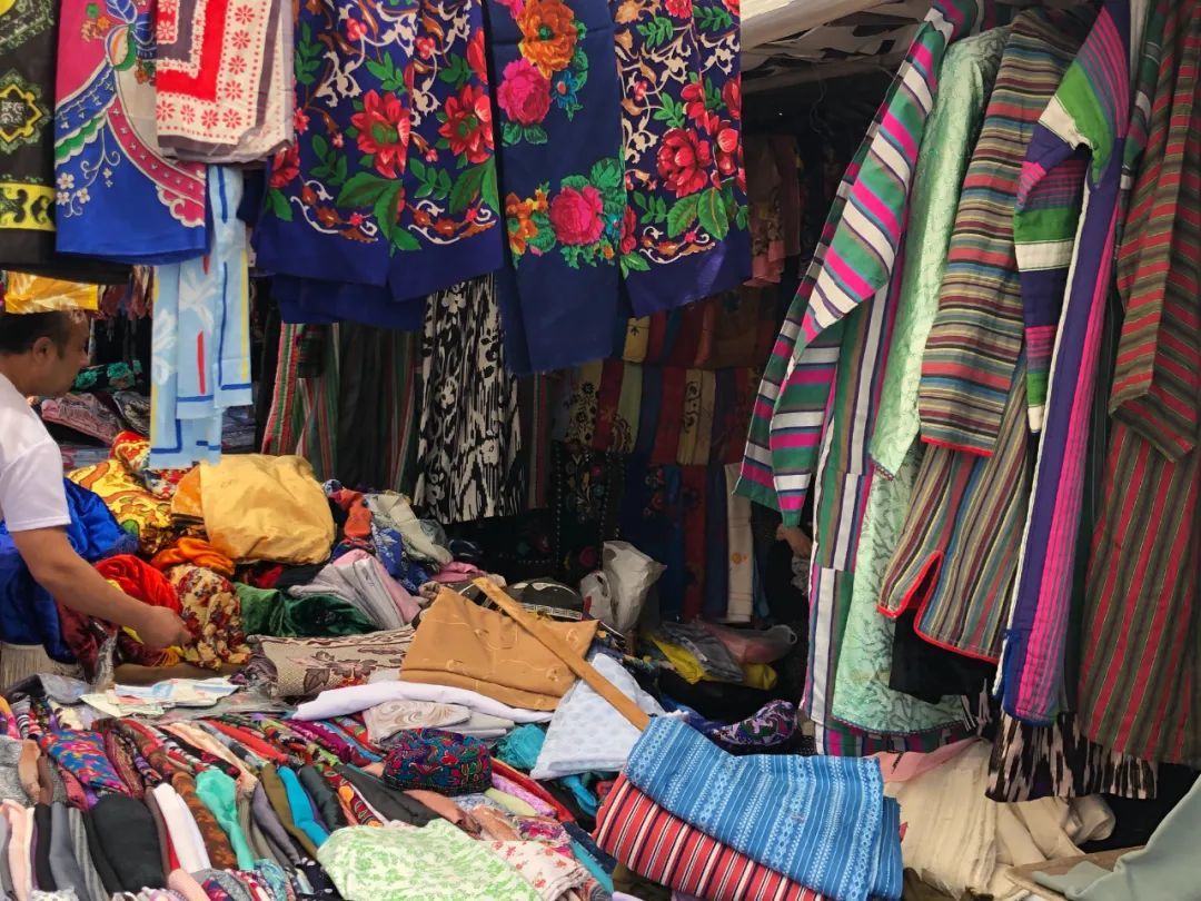 △扬吉奥巴德巴扎里的纺织品摊位,卖袷袢(彩色条纹大衣)艾德莱斯和各种色彩鲜艳的织物