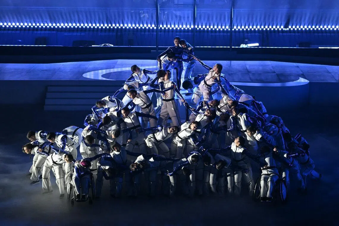 演员们用道具建构起雪山的形象，单腿截肢的意大利体操选手吉奥吉亚·格雷科（上）在演员们的托举下登临雪山之巅，寓意着残疾并非缺失、而是力量，并非局限、而是可能。（法新社）