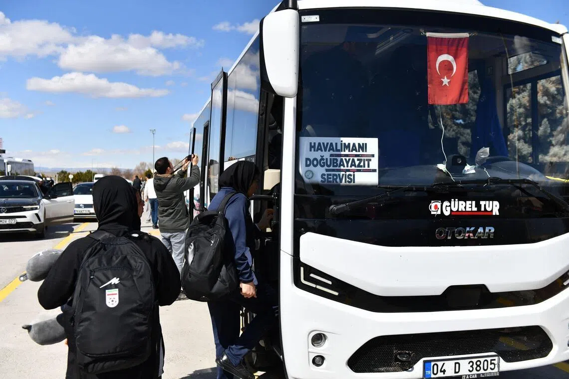 伊朗女足队成员在厄德尔机场登上巴士，前往边境口岸，回到伊朗。（法新社）