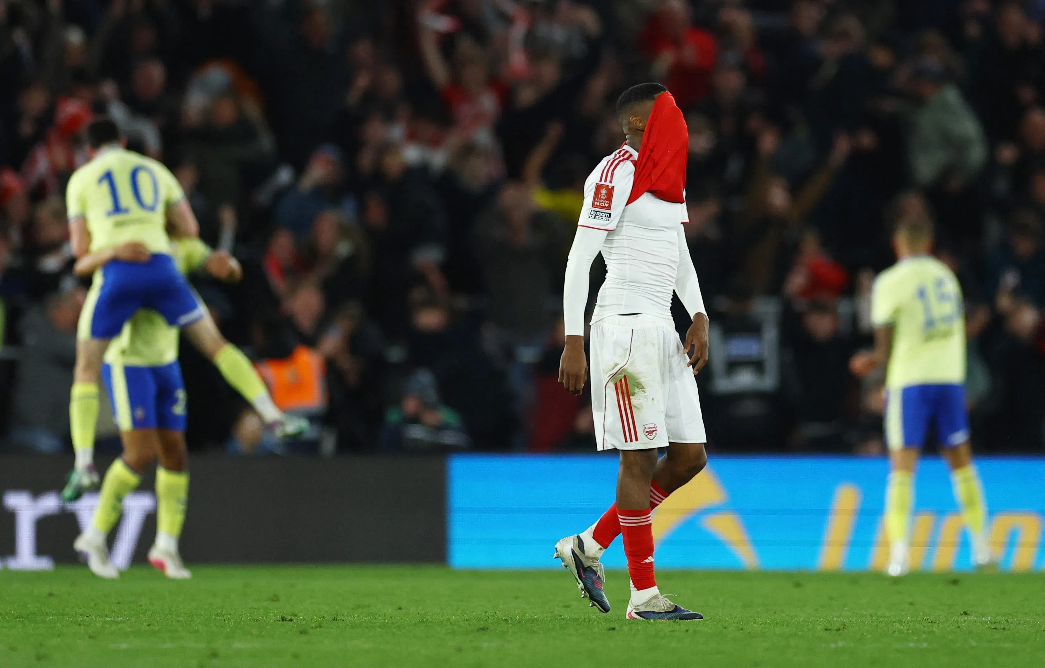 阿申纳后卫莫斯奎拉（中）赛后“没脸见人”，和一旁兴奋庆祝的南安普敦球员形成强烈对比。（路透社）