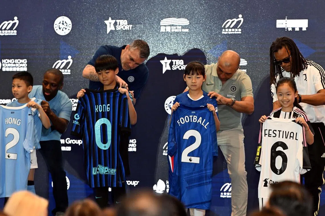 戴维斯（后排右）在香港足球盛会新闻发布会上为小朋友签名。发布会上宣布曼市、切尔西、国际米兰和尤文图斯将在今年8月来港踢季前热身赛。代表其他三队出席这场活动的前球员分别是（左起）曼市的菲利普斯、国米的维埃里和切尔西的迪马泰奥。（新华社）