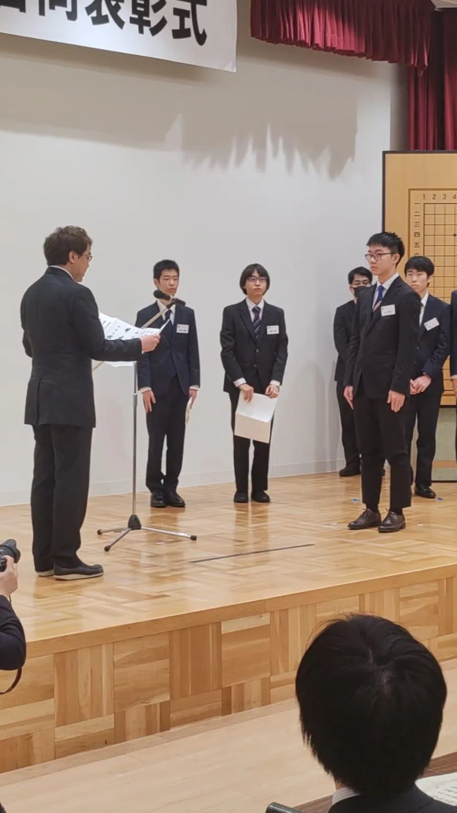 日本棋院理事长武宫阳光（左）宣布陈奕航（前排右）职业入段。（陈明耀摄）