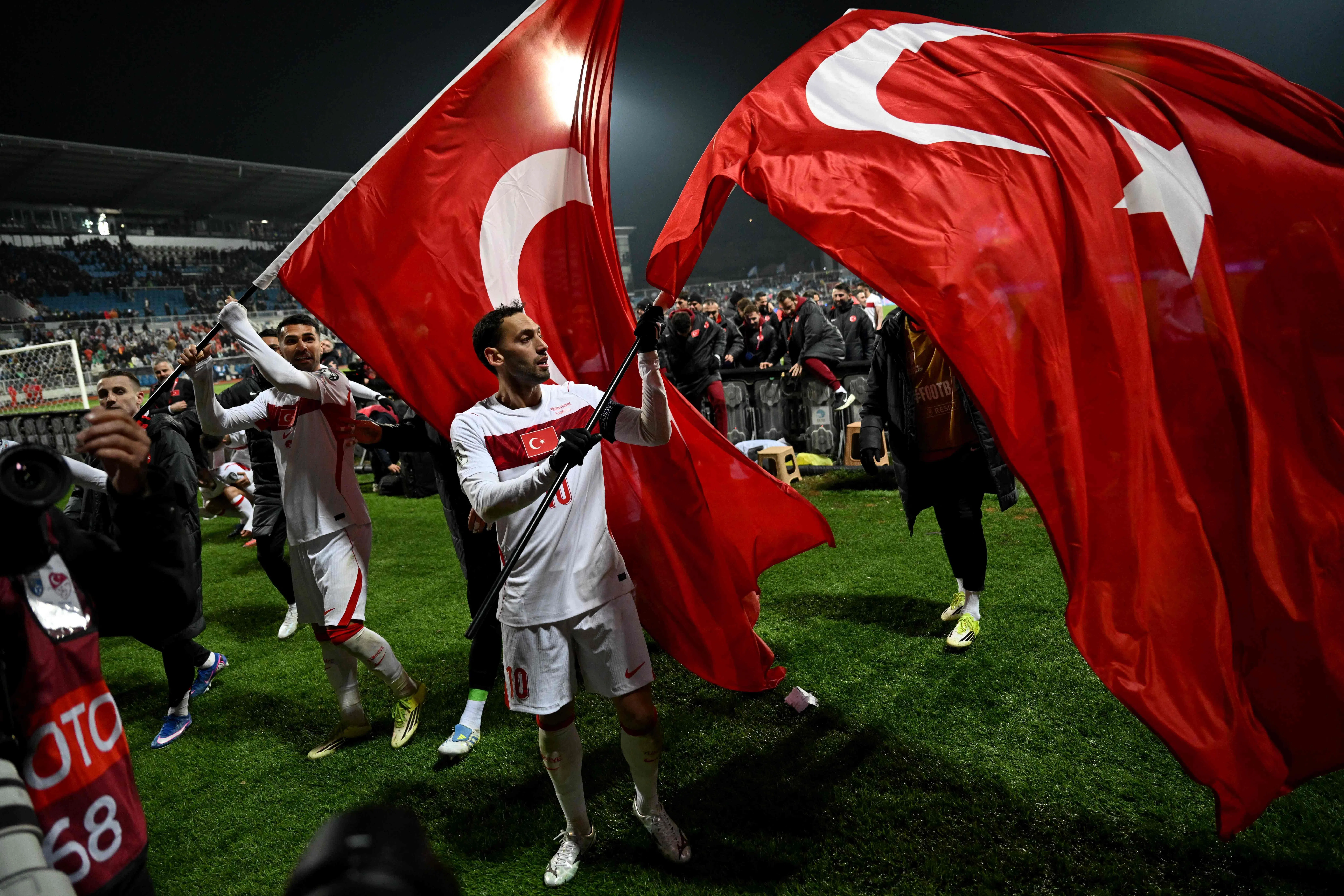 土耳其前锋恰尔汗奥卢（Calhanoglu）赛后在客场球迷前挥舞土耳其国旗庆祝胜利。（法新社）